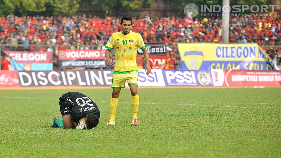 Kiper Persibat Batang, Sendri Johansyah, menangkap bola yang mengancam gawangnya disaksikan oleh pemain Cilegon United, Afriansyah. Pertandingan dilaksanakan di lapangan sepakbola Krakatau Steel, Cilegon, Banten, Minggu (28/09/14).